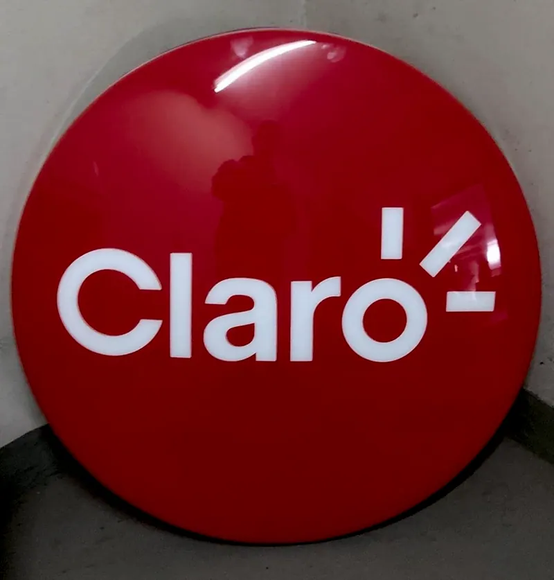 Luminoso redondo vermelho da Claro, com a marca em branco