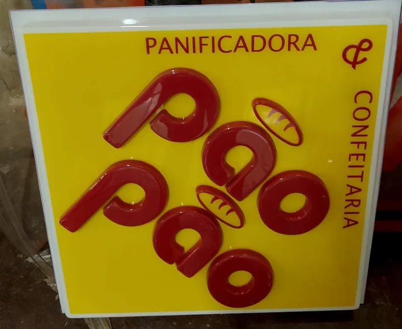 Placa amarela da panificadora Pão Pão, com as letras moldadas em vermelho