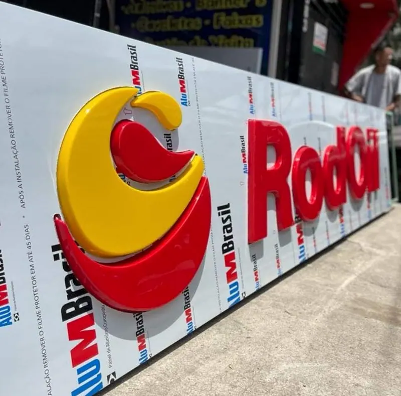 Letreiro RodOil em letras moldadas, vermelho e amarelo, sobre painel em ACM