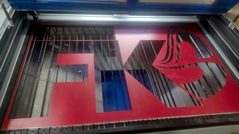 Corte a laser de letras vermelhas FK dentro da máquina