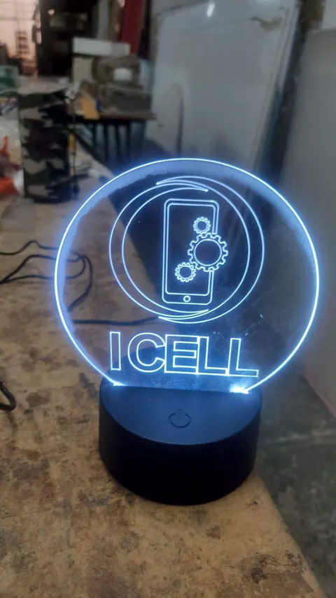 Luminária de acrílico ICELL acesa, com a marca gravada